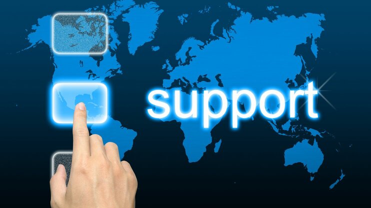 Hand zeigt auf Weltkarte mit „Support“-Schriftzug – Symbolbild für internationalen Kundenservice