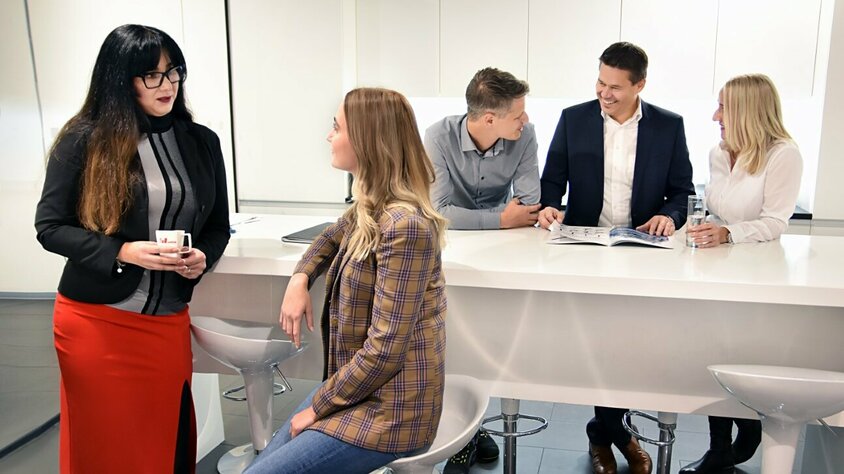 Angestellte der weba Werkzeugbau stehen in der Kaffeeküche und unterhalten sich.