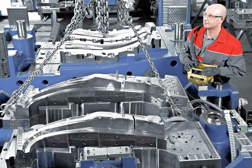 Ein Werkzeugbautechniker bedient eine Krananlage um Aktivteile eins Warmumformwerkzeuges bei weba Werkzeugbau zu montieren