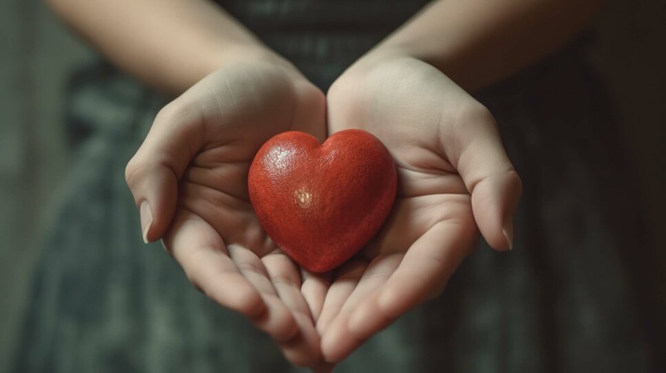Corporate Social Responsibility - Sponsoring Delicate hands hold a radiant red heart, symbolizing love, health, and the spirit of giving and humanity. The image is symbolically used by weba to represent Corporate Social Responsibility in connection with sponsorship and charity.