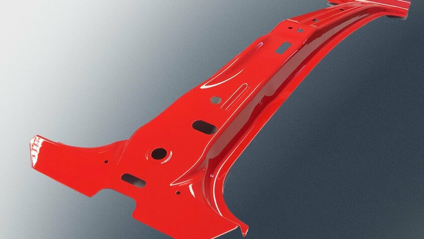 Metallisches Bauteil aus dem Prototypenbau von weba Deutschland, lackiert in Rot, mit komplexer Geometrie und mehreren Durchbrüchen, vor einem dunklen Hintergrund.