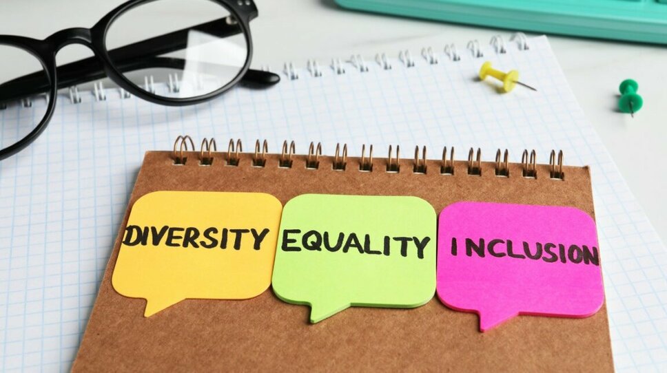 Work Culture and Career in Steyr - Inclusivity, Diversity, and Equality  Backside of a notepad with three colorful post-its displaying the words "Diversity, Equality, and Inclusion." Next to it are a pair of black-rimmed glasses, a turquoise keyboard, and two push pins in green and yellow.