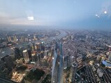 Aerial view of Shanghai’s skyline at dusk with the Huangpu River and glowing skyscrapers – a memorable moment from Jan Wengryn’s assignment in China.