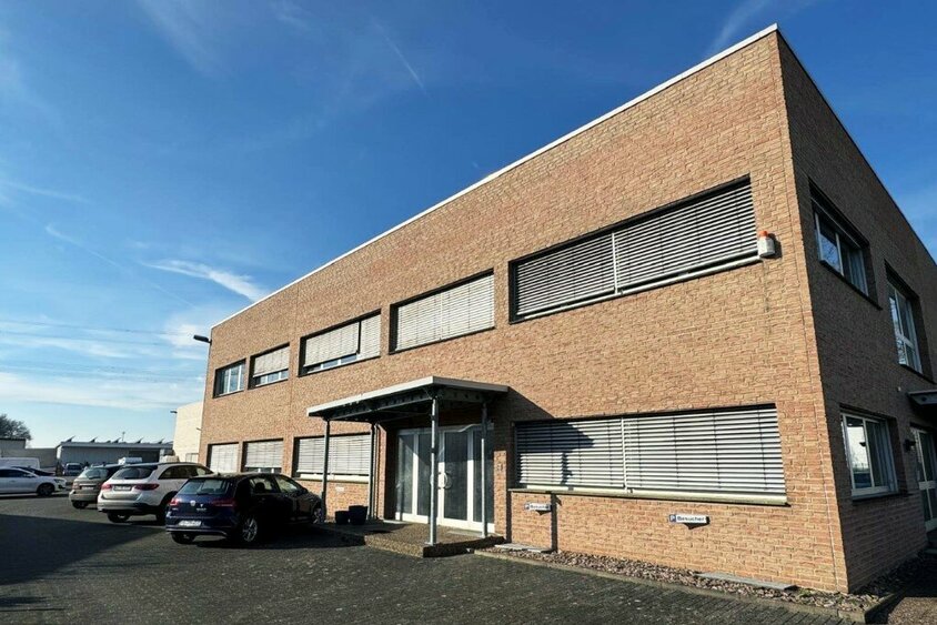 Das Firmengebäude der weba Deutschland GmbH, einem Experten für Prototypenbau, bei sonnigem Wetter mit Parkplätzen und moderner Architektur.