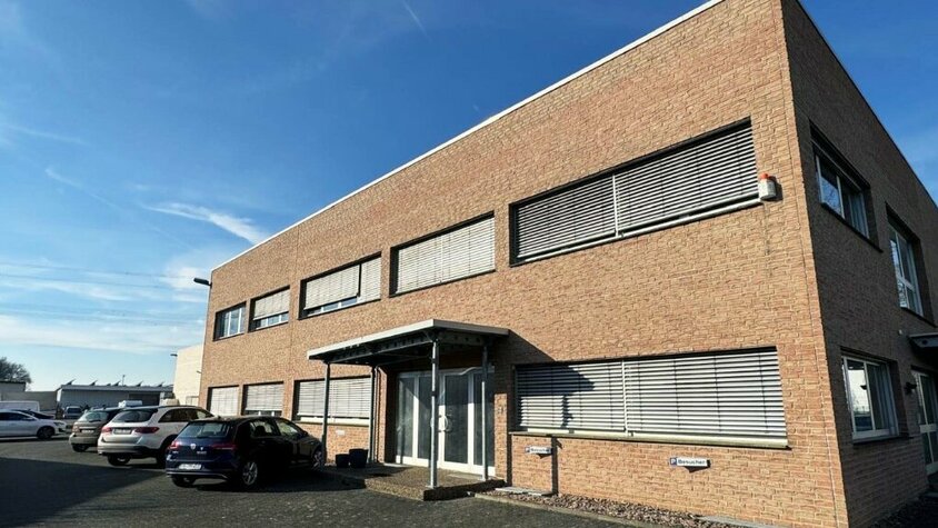 Das Firmengebäude der weba Deutschland GmbH, einem Experten für Prototypenbau, bei sonnigem Wetter mit Parkplätzen und moderner Architektur.