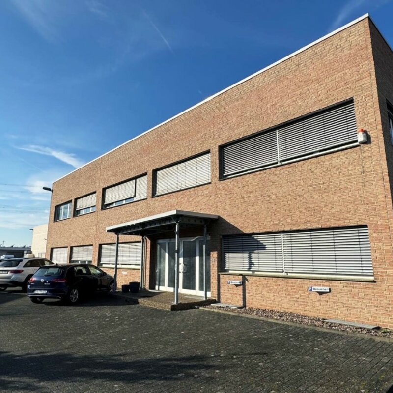 weba Deutschland GmbH – Ihr Experte für Prototypenbau Das Firmengebäude der weba Deutschland GmbH, einem Experten für Prototypenbau, bei sonnigem Wetter mit Parkplätzen und moderner Architektur.