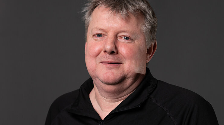 Klaus Postlbauer, procesní manažer výroby nástrojů ve společnosti weba, se usmívá do kamery na neutrálním pozadí. Do kamery se dívá s klidným vystupováním a lehkým úsměvem. Snímek vyjadřuje odbornost a přízemní přístup - v souladu s jeho dlouholetým vztahem ke společnosti weba Werkzeugbau.