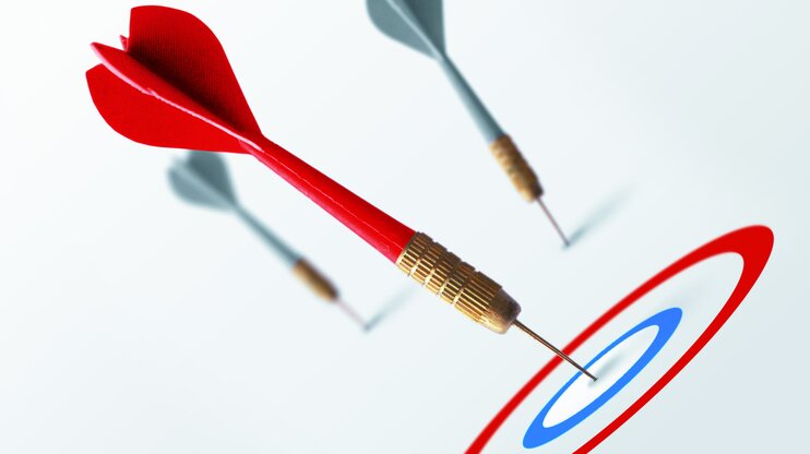 Red dart hitting the bullseye while two gray darts miss the target – symbolizing clear goal-setting with the SMART method.