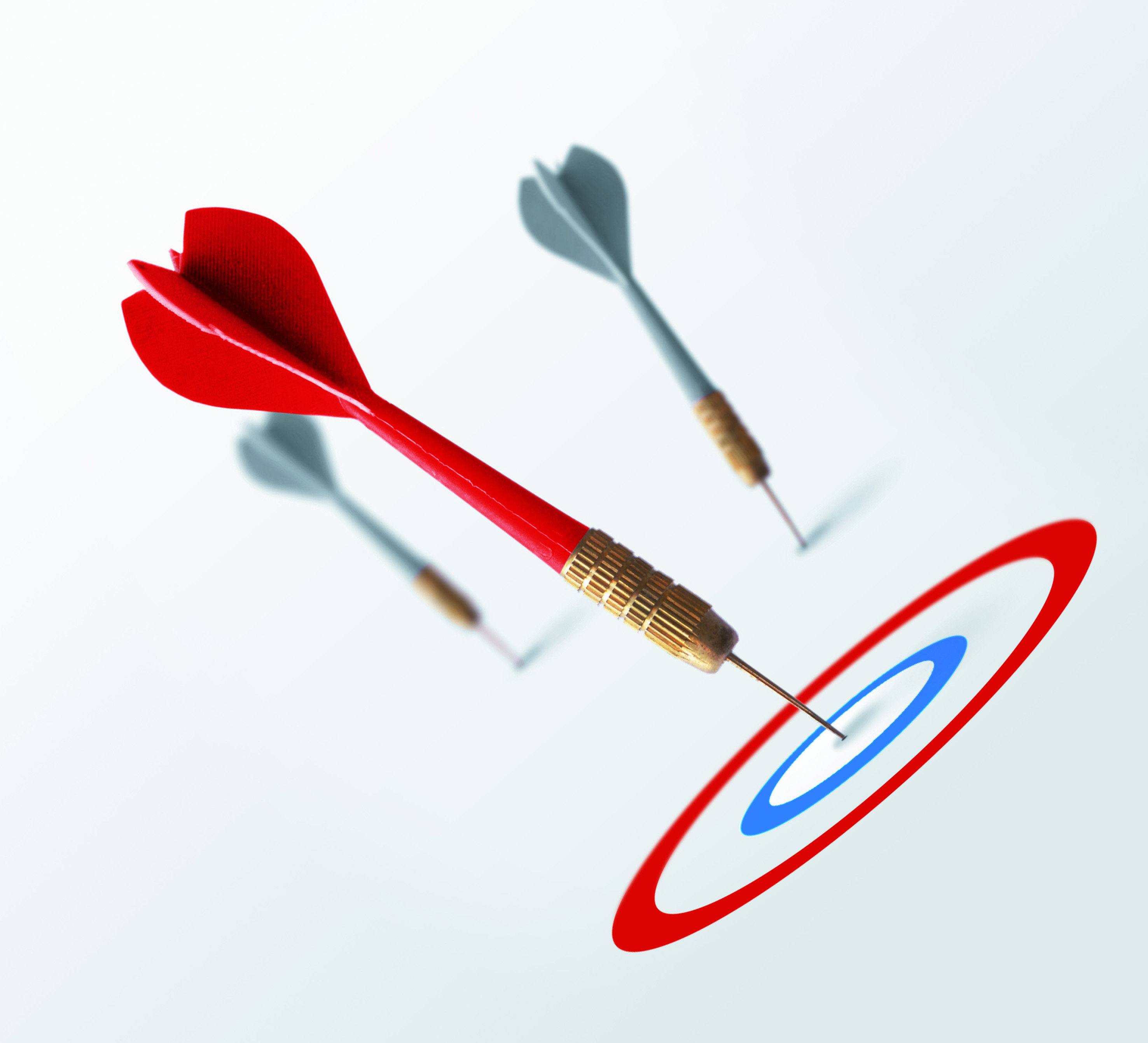 Red dart hitting the bullseye while two gray darts miss the target – symbolizing clear goal-setting with the SMART method.