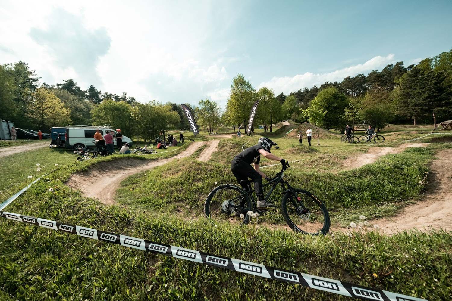Radek Šimek rides his mountain bike with helmet through a winding dirt track during training.