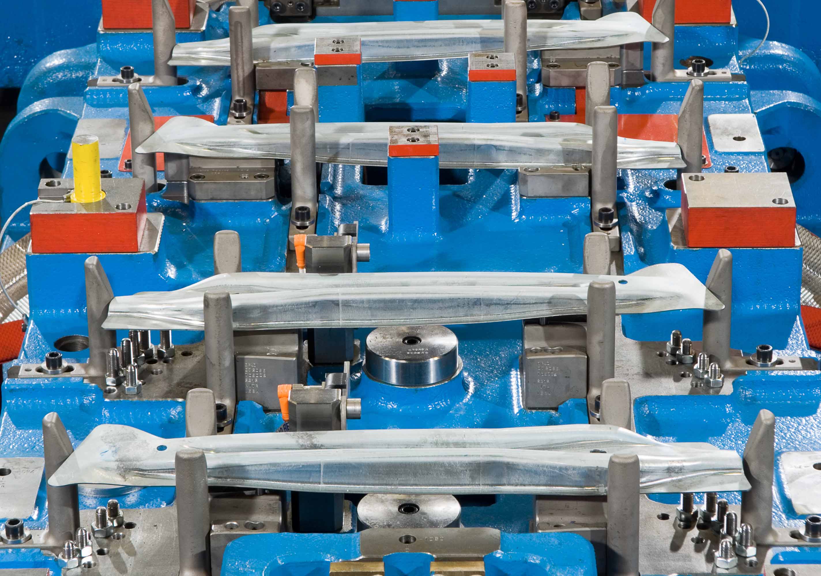 Transfer die for cold forming in detail: multiple fixed sheet metal parts in a precisely manufactured tool for producing door impact beams in the automotive industry.